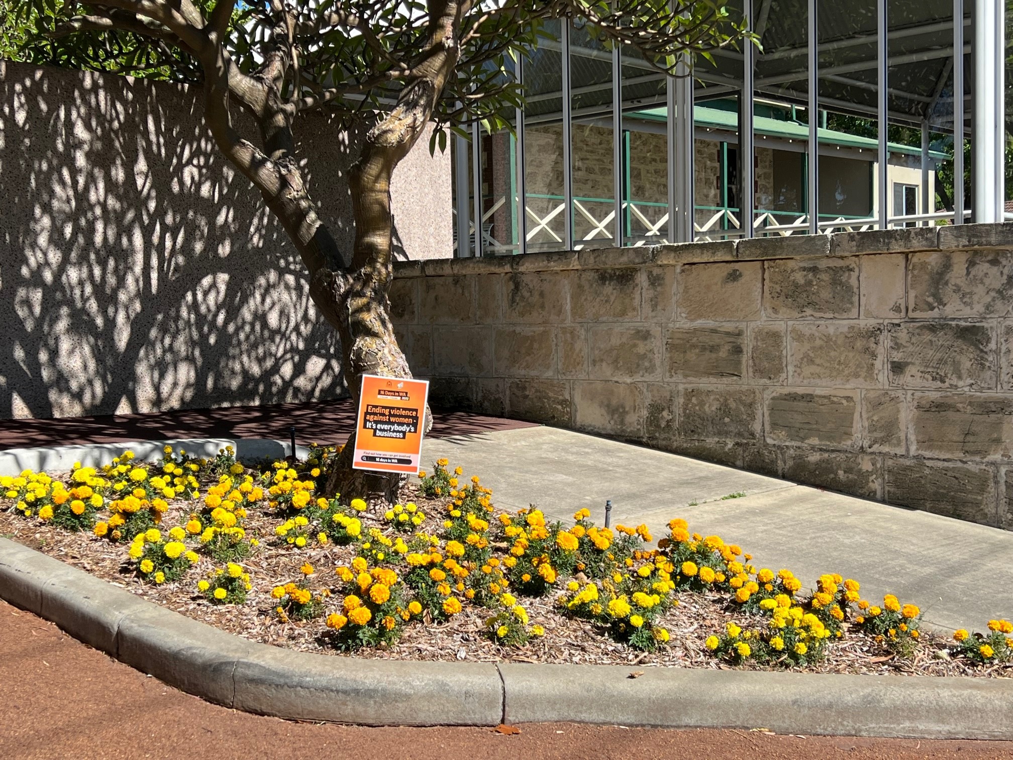 the entrance of the cortege driveway of Fremantle Cemetery displaying marigold flowers in a garden bed