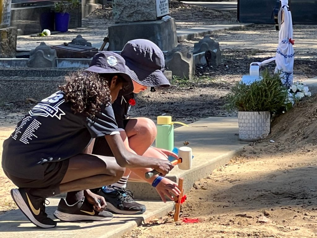 Frreshwater Bay students placing the cross at the gravesite.