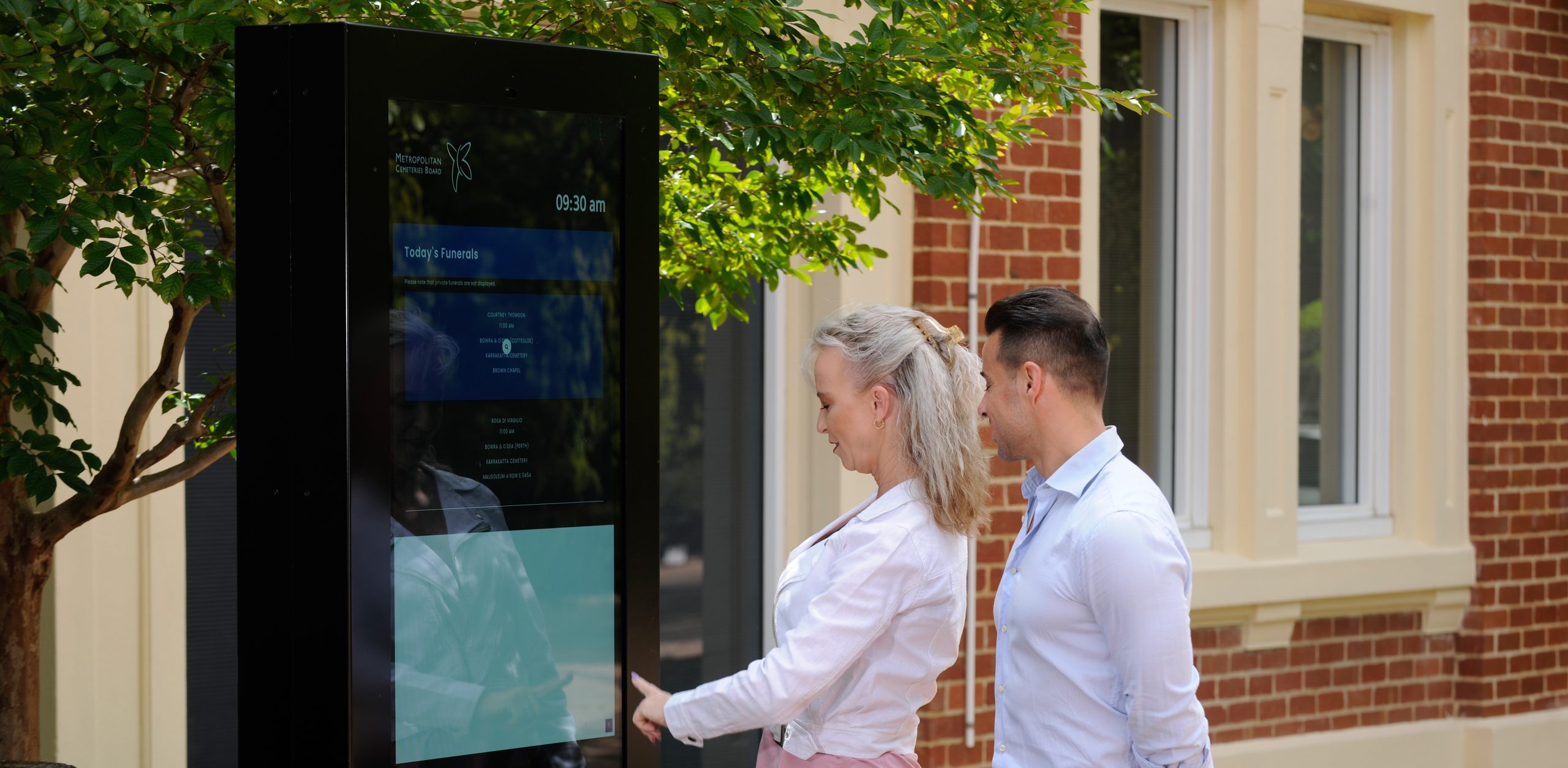 patrons using the Digital Information Board outside administration at Karrakatta Cemetery