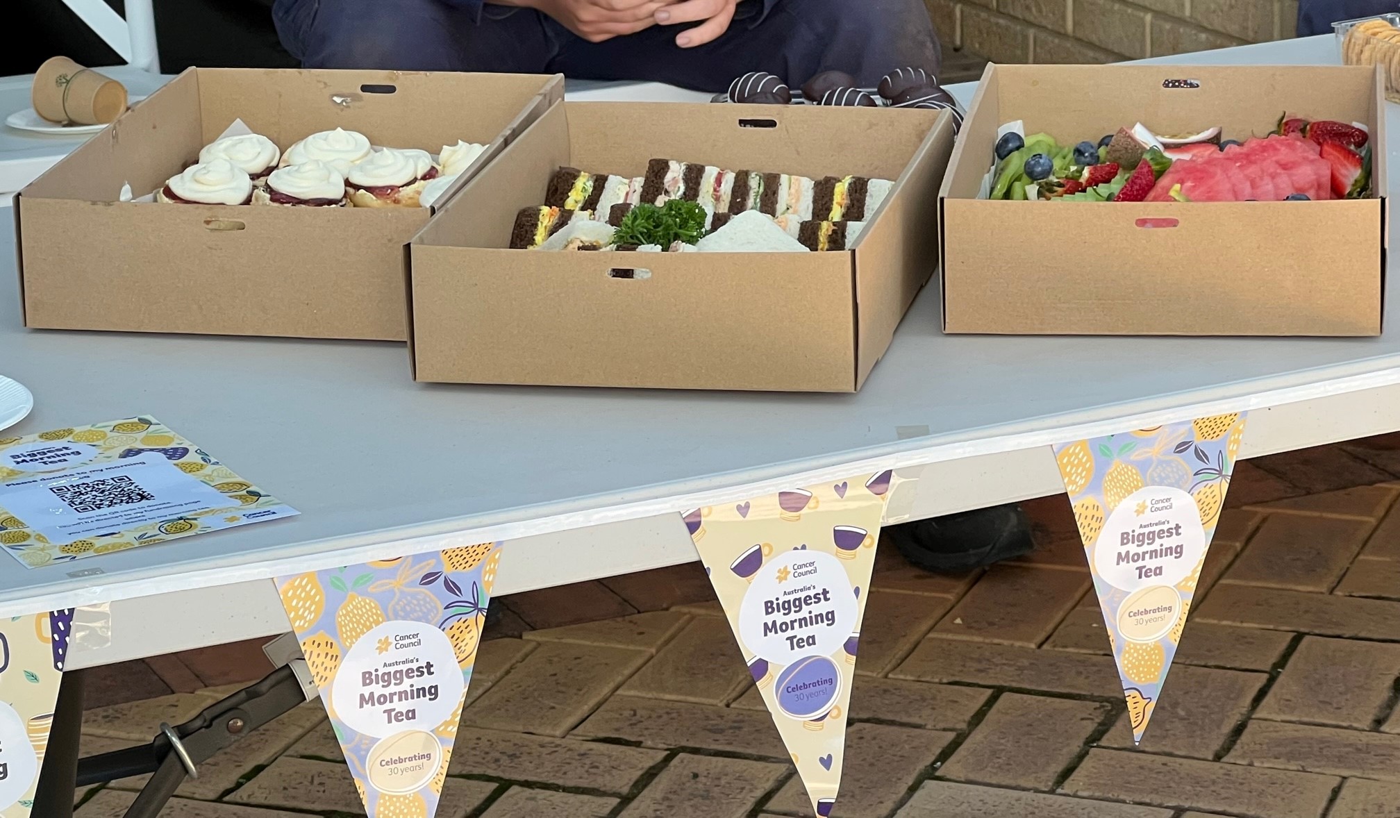 jam and cream scones, gourmet sandwiches and a selection of summer fruits in cardboard boxes in celebration of Harmony Day